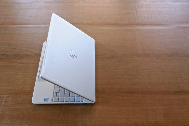 Een witte laptop zittend op een houten tafel.