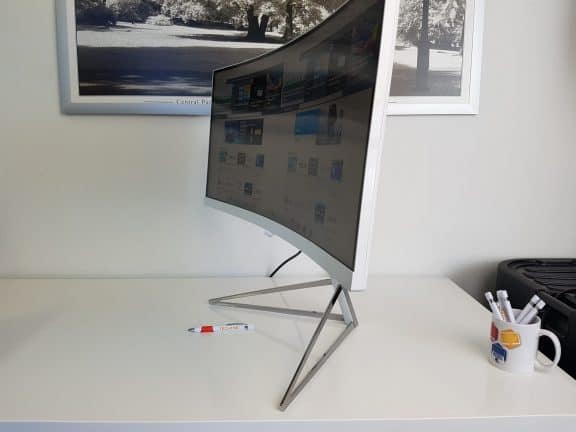 Een Philips 349X7FJEW/00 monitor op een bureau met een foto erop.