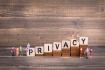 Een groep mensen staat naast het woord privacy op een houten achtergrond en benadrukt het belang van privacy bij het bereiken van tastbare resultaten voor bedrijven die erin investeren.