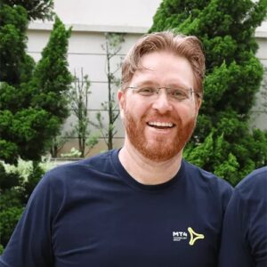 Twee mannen in t-shirts lachend naar de camera.