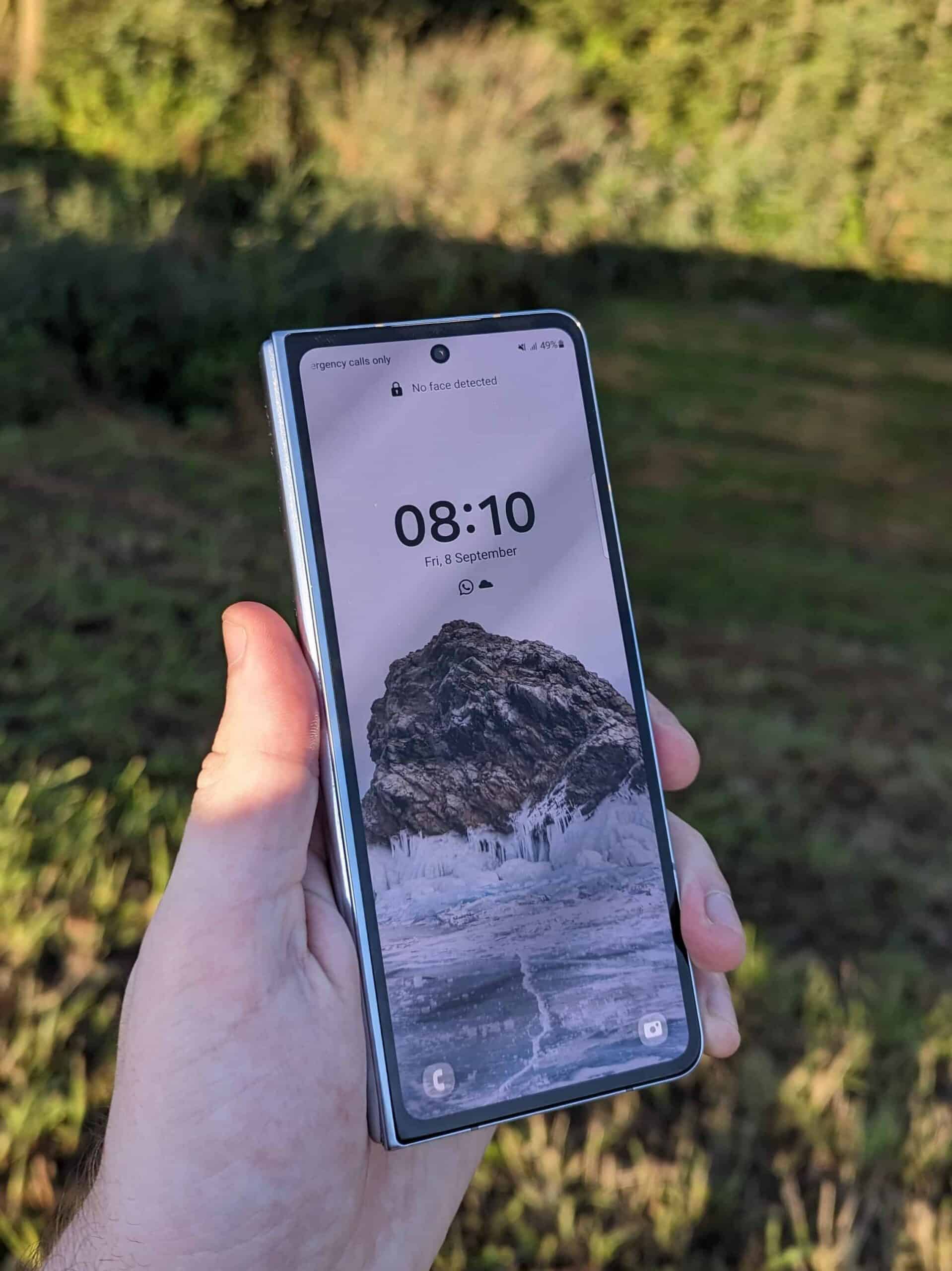 Een hand die een Nokia Xperia Z2-smartphone vasthoudt in een veld.