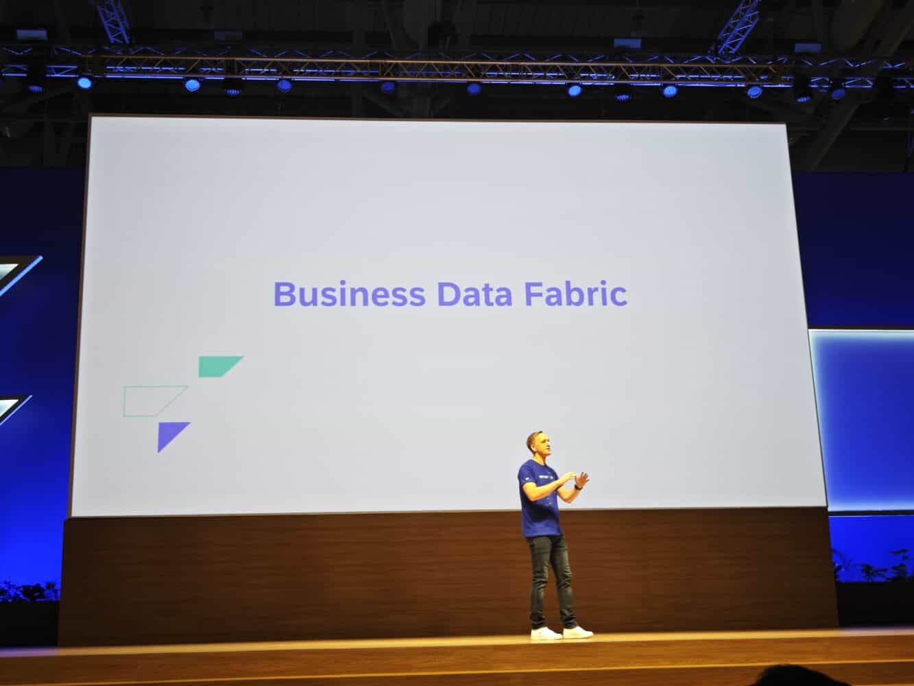 Een man die voor een scherm staat met de woorden business data fabric.