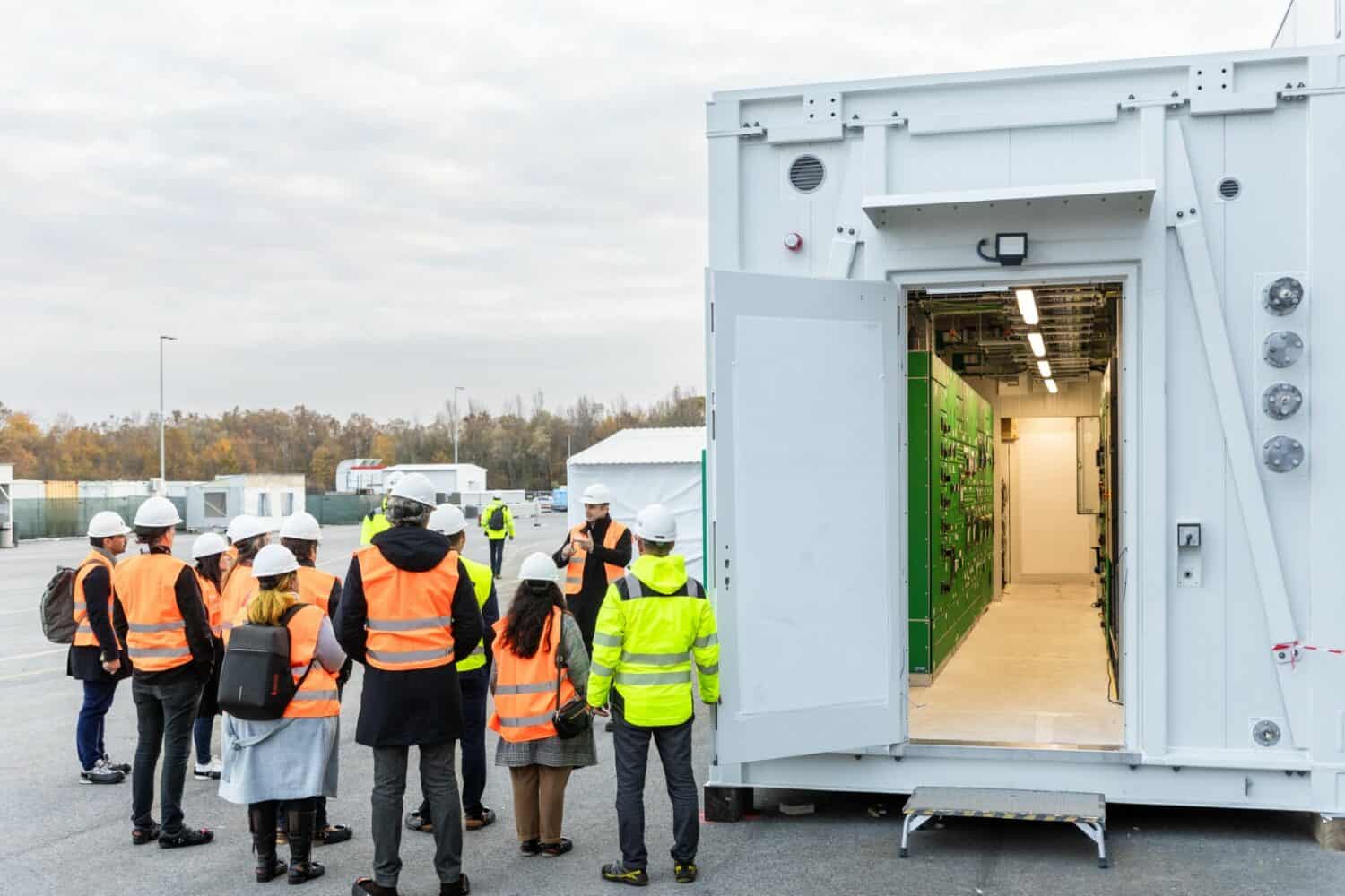 Een groep mensen staat voor een grote container.