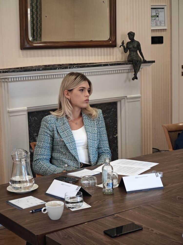 Twee vrouwen zitten aan een tafel voor een open haard.