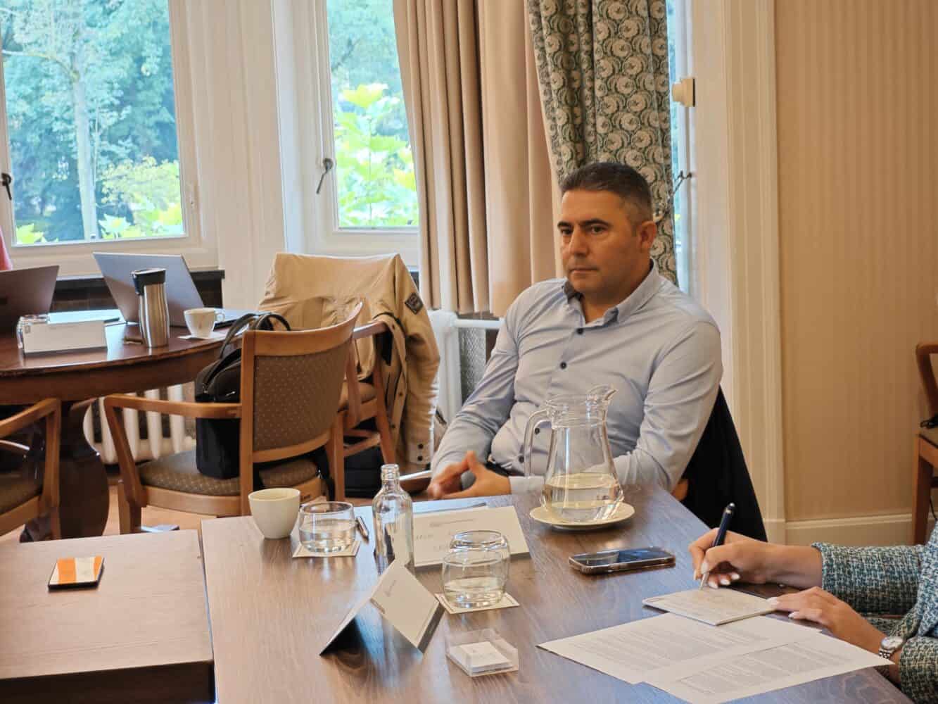 Een man en een vrouw zitten aan een tafel.