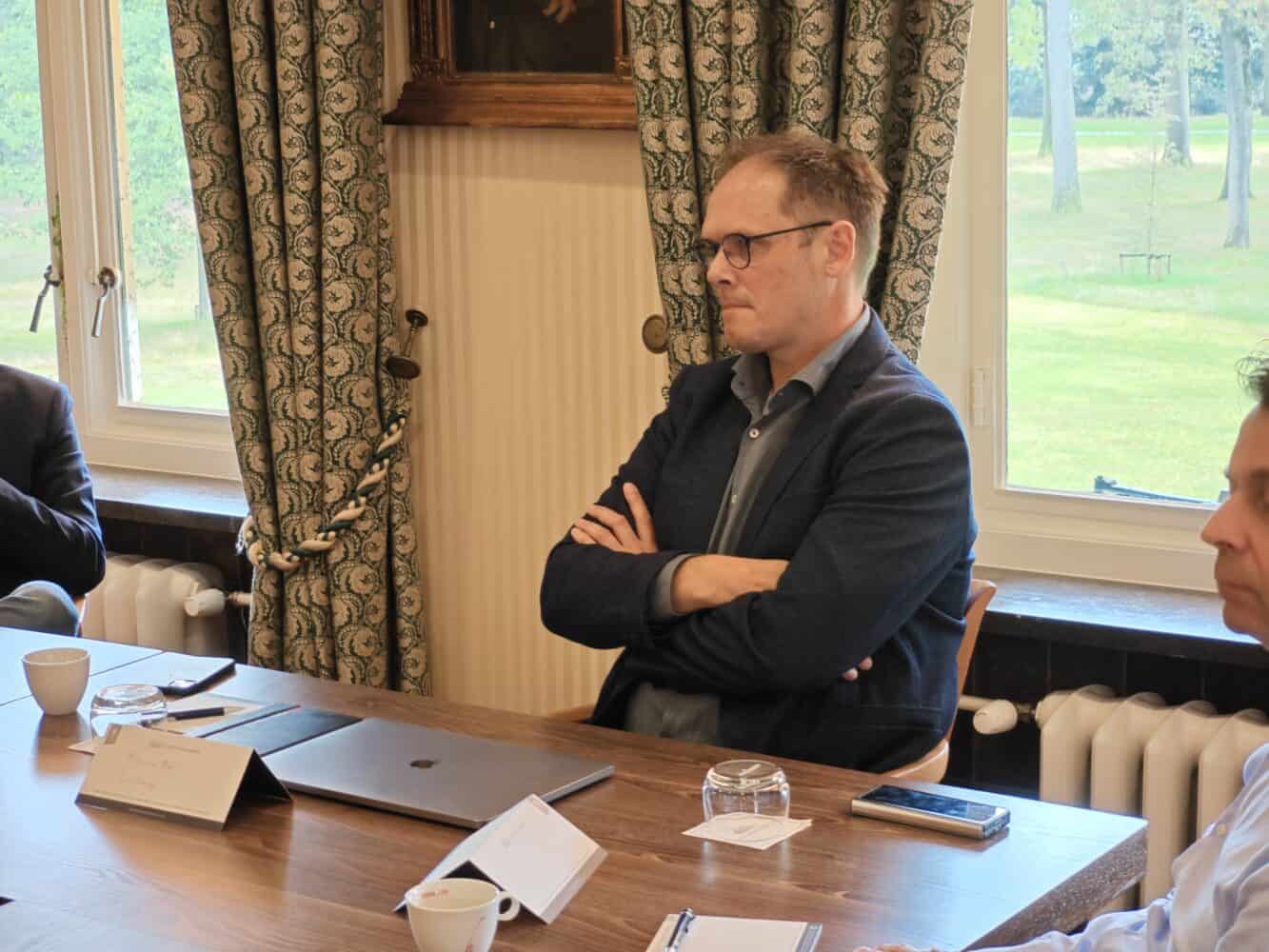 Een groep mensen zit rond een tafel.