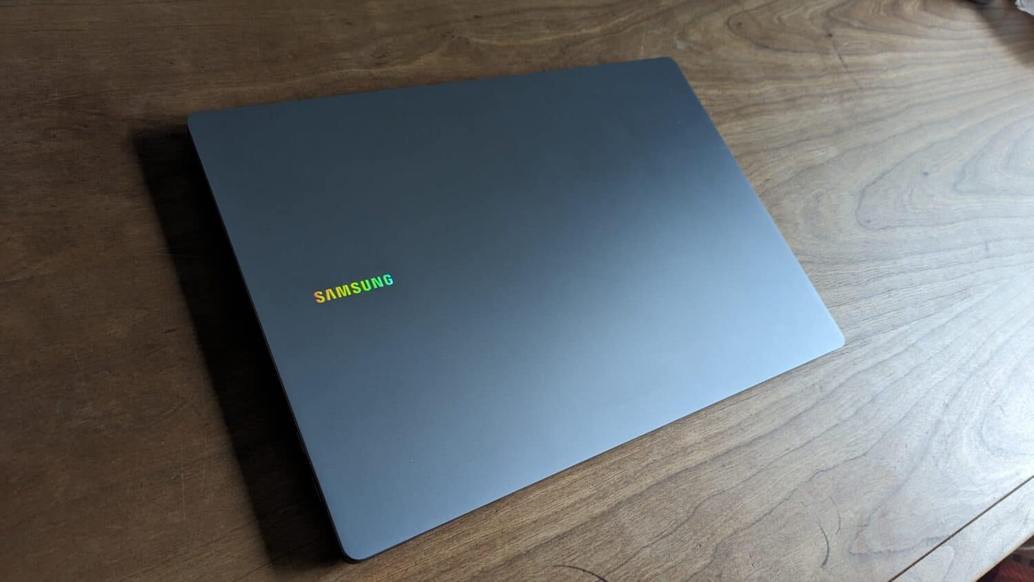 Een gesloten Samsung Galaxy Book4 Ultra op een houten tafel, vanuit een kleine hoek bekeken, met het logo van het merk op de deksel.