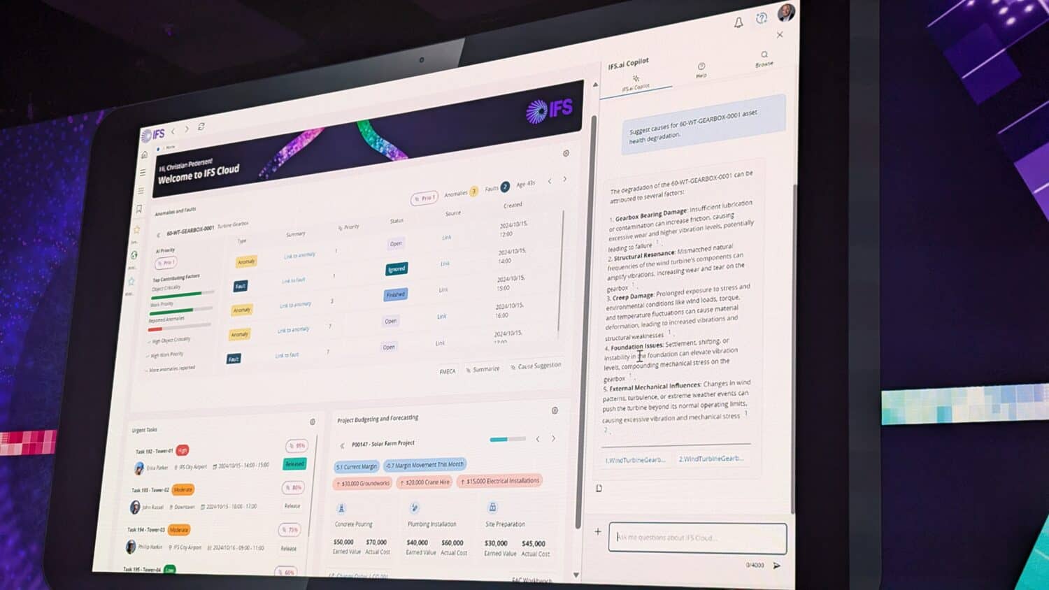 PXL_20241015_132900380.MP Op een computerscherm wordt een software-interface weergegeven met een dashboard met tabellen, grafieken en een chatfunctie op een donkere achtergrond.