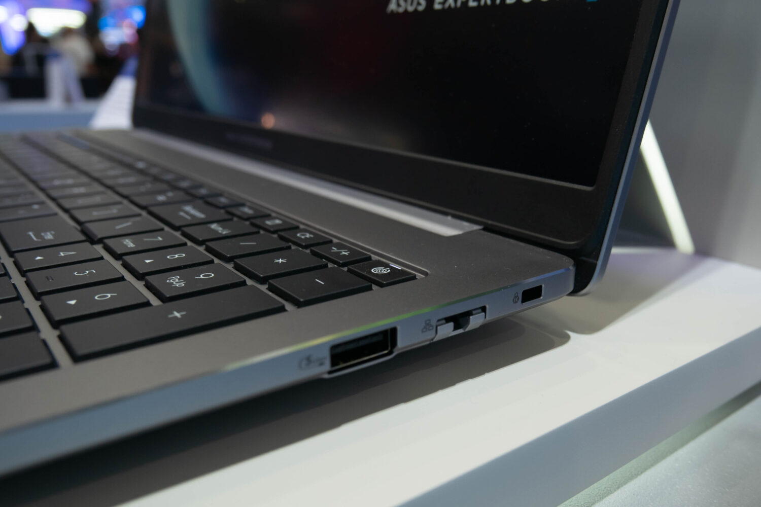 Close-up van een laptop met het toetsenbord, de randaansluitingen, waaronder een USB- en microSD-kaartslot, en een deel van het scherm.
