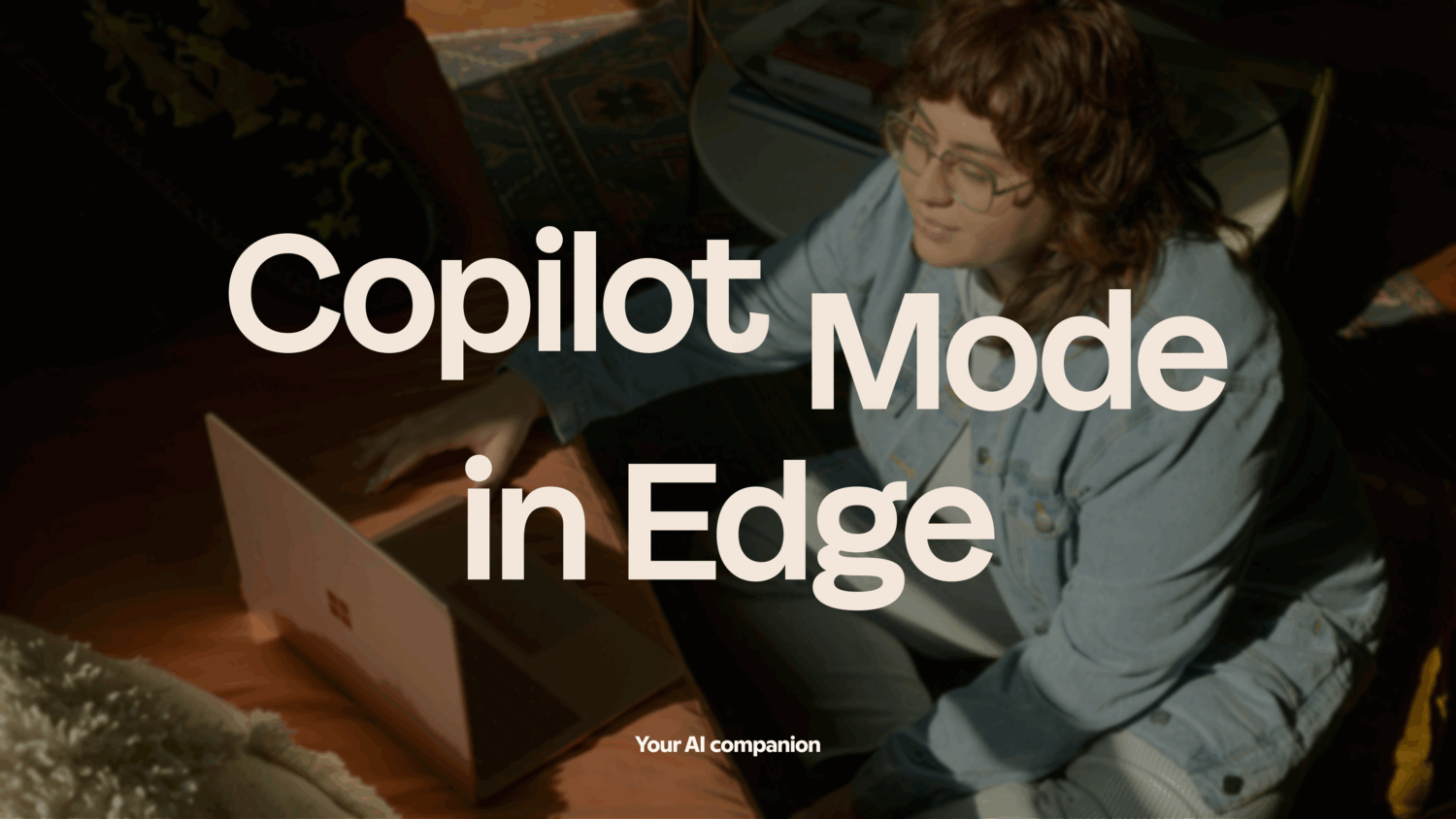 Een persoon in vrijetijdskleding gebruikt een laptop terwijl er in grote overlappende tekst "Copilot Mode in Edge" staat. Onderaan staat "Je AI metgezel.