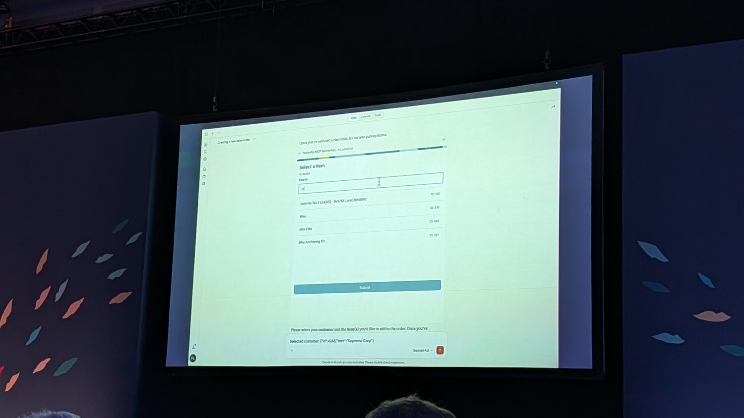 Een groot scherm toont een webformulier met de titel "Selecteer een plan" met meerdere abonnementsopties tijdens een presentatie op een evenement.